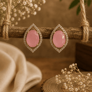 Pink teardrop halo stud earrings with pavé crystal border, gold-tone setting.