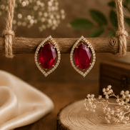 Red teardrop halo stud earrings with pavé crystal border, gold-tone setting.
