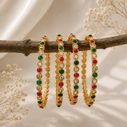 Nayra Royal gold-tone bangles with green and pink bead rows and red center stones