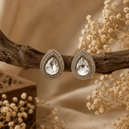 Gold-tone teardrop stud earrings with clear center crystal and sparkling halo border