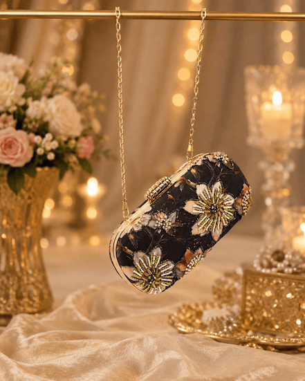 Black embellished floral clutch bag with gold beaded chain shoulder strap.