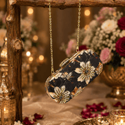 Black floral clutch purse with jeweled clasp and gold chain shoulder strap