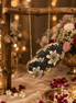 Black floral clutch purse with jeweled clasp and gold chain shoulder strap
