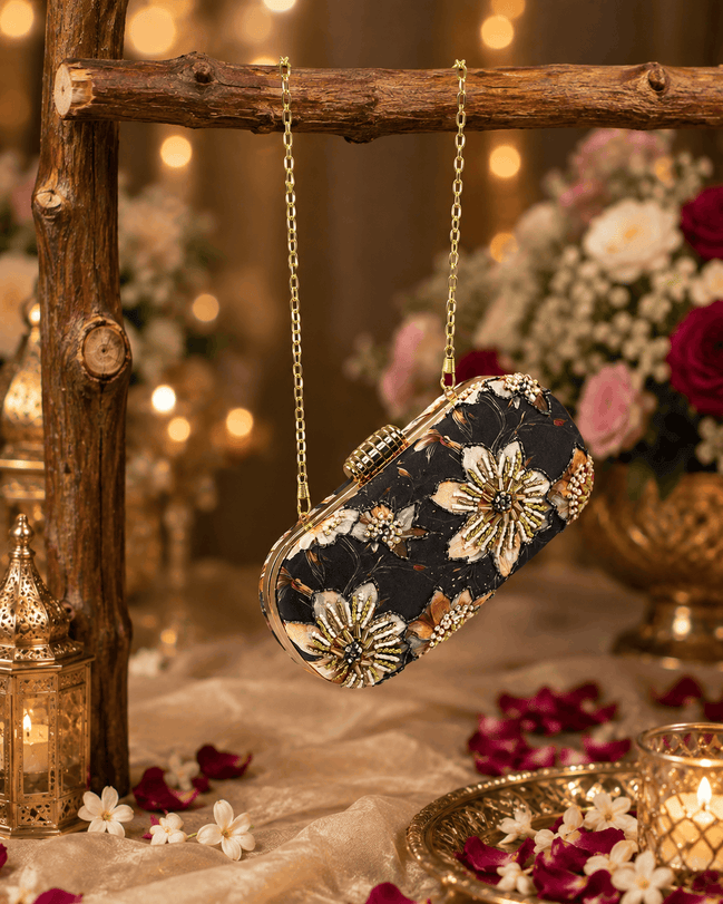 Black floral clutch purse with jeweled clasp and gold chain shoulder strap