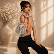 Silver beaded potli bag with drawstring and dangling tassels.