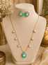 Gold-tone necklace with turquoise center pendant and matching stud earrings