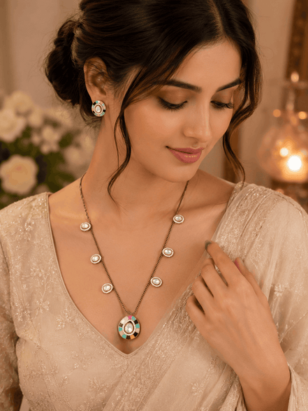 Gold-tone necklace with turquoise center pendant and matching stud earrings on model