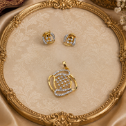 Gold-tone pendant and blue crystal stud earrings on ornate round tray