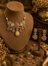 Gold-toned choker necklace with teardrop charms and matching stud earrings