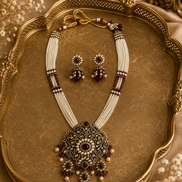 Heritage necklace set with layered bead strands, ornate pendant and matching drop earrings.