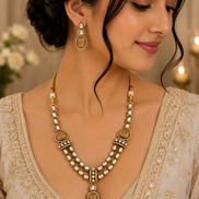 Gold kundan necklace set with peacock-blue teardrop pendant and matching drop earrings