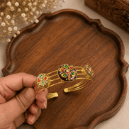 Gold-tone cuff bracelet with peacock enamel centerpiece and round side details