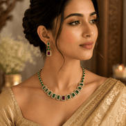 Gold-tone necklace with green stones and red-accent stud earrings