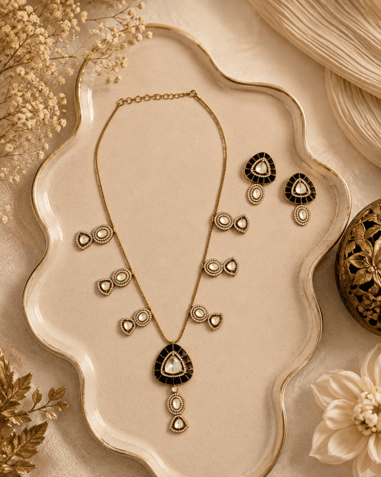 Black teardrop pendant necklace set with matching gold stud earrings and drop details