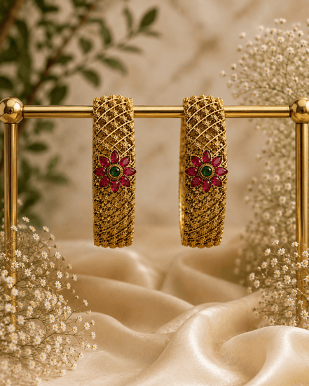 Pair of antique gold bangles with pink & green floral center stones, lattice hoop cuffs
