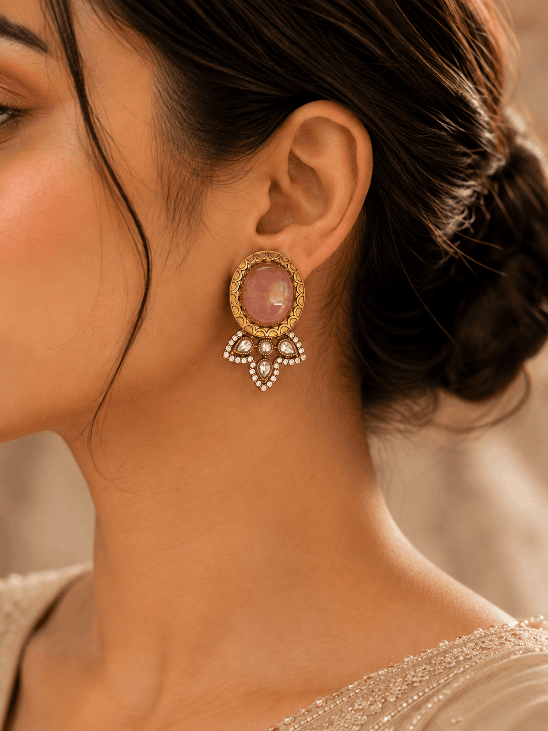 Pink oval stud earrings on-ear with gold halo and crystal bow dangles