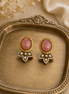 Pink oval stud earrings with gold frames and crystal teardrop dangle details