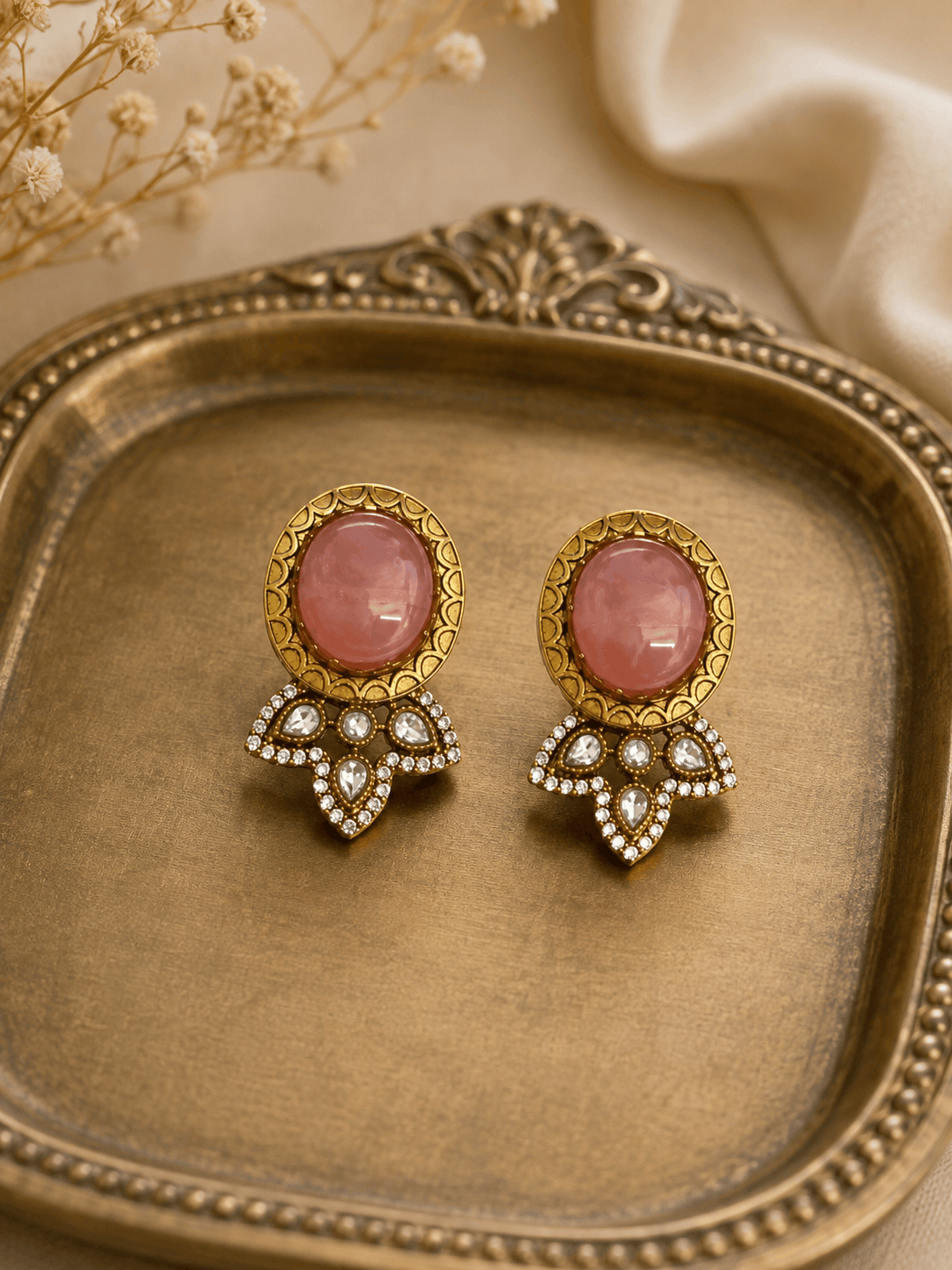Pink oval stud earrings with gold frames and crystal teardrop dangle details