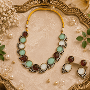 Multicolor stone choker necklace with matching earrings on an ornate tray