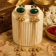 Gold tassel earrings with oval green stones, green enamel accents, and long beaded drops