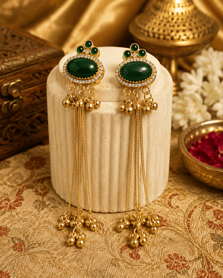 Gold tassel earrings with oval green stones, green enamel accents, and long beaded drops