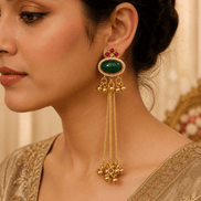 Gold oval gemstone tassel earrings with beaded drops, worn on a model in profile