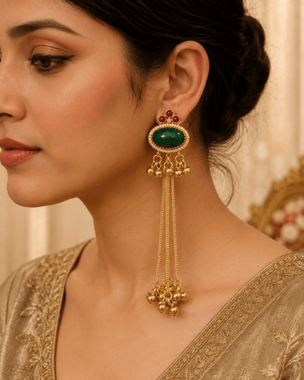 Gold oval gemstone tassel earrings with beaded drops, worn on a model in profile