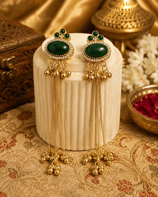 Gold tassel earrings with oval green stones, green enamel accents, and long beaded drops