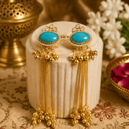 Gold tassel earrings with oval teal stones, rhinestone halo, and dangling beaded drops