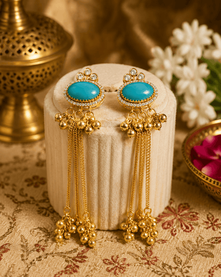 Gold tassel earrings with oval teal stones, rhinestone halo, and dangling beaded drops