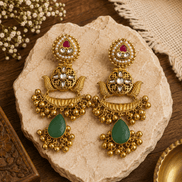 Gold kundan pearl-style jhumka earrings with green and purple teardrop stones