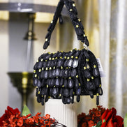 Black beaded hobo bag with dangling teardrop charms and top handles