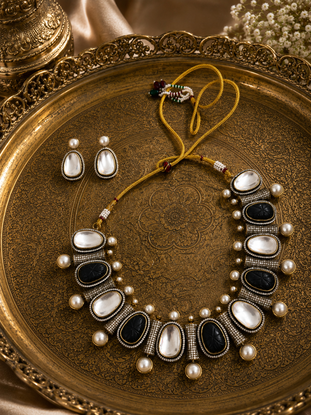 Mahira Heritage necklace set with black and white stones and pearls, shown with stud earrings.