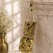 Gold filigree mobile clutch hanging on chain strap with green and purple jeweled accents