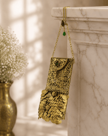 Gold filigree mobile clutch hanging on chain strap with green and purple jeweled accents