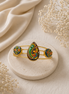 Gold-tone cuff bracelet with three colorful enamel motifs in green, blue, and gold