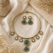 Gold-tone necklace and green teardrop earrings set with round crystal details