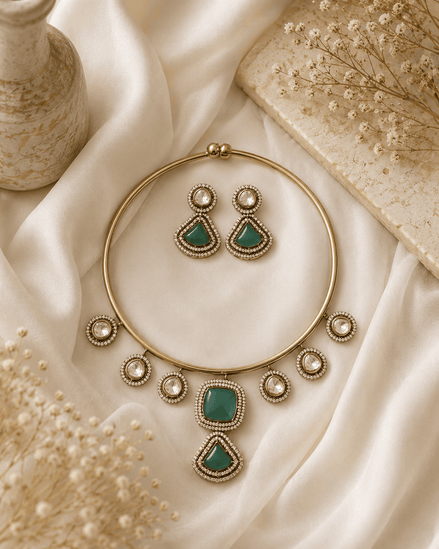 Gold-tone necklace and green teardrop earrings set with round crystal details