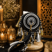 Black beaded potli bag with circular mirrorwork pattern and tassel fringe