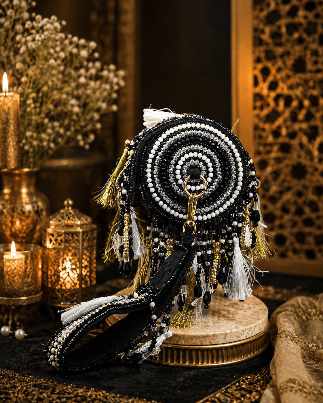 Black beaded potli bag with circular mirrorwork pattern and tassel fringe
