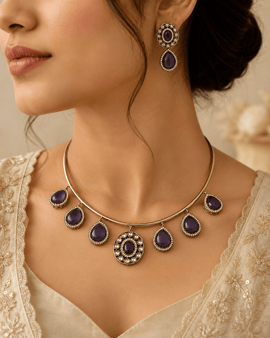 Gold-tone necklace with purple teardrop stones and matching drop earrings