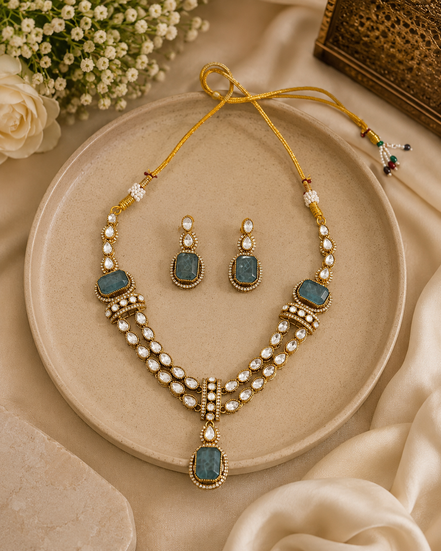 Gold kundan necklace and earrings set with peacock-blue teardrop stones and pearl drops