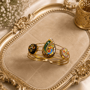 Gold-tone cuff bracelet set with three colorful enamel paisley motifs on bangles