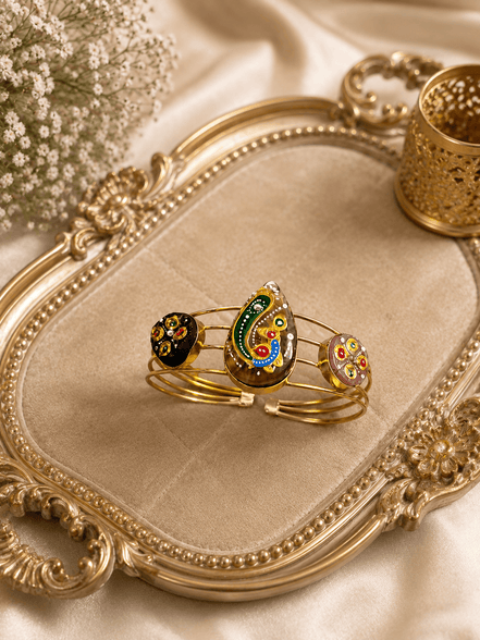Gold-tone cuff bracelet set with three colorful enamel paisley motifs on bangles