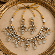 Gold-tone necklace set with white teardrop stones and matching chandelier earrings