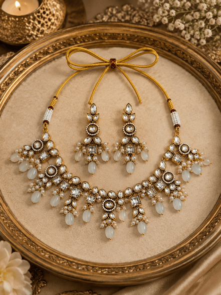 Gold-tone necklace set with white teardrop stones and matching chandelier earrings