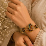 Gold-tone cuff bracelet with multicolor round and oval enamel detailing on wrist