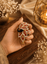 Gold kada with maroon and red stones, black centerpiece, dangling teardrop charm