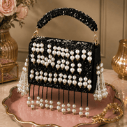 Black beaded pearl shoulder bag with gold chain handles and dangling pearl tassels
