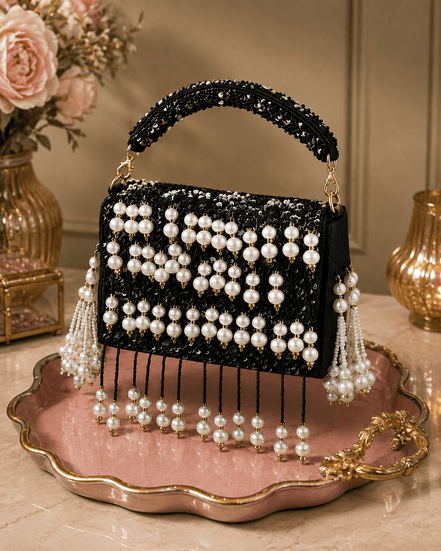 Black beaded pearl shoulder bag with gold chain handles and dangling pearl tassels